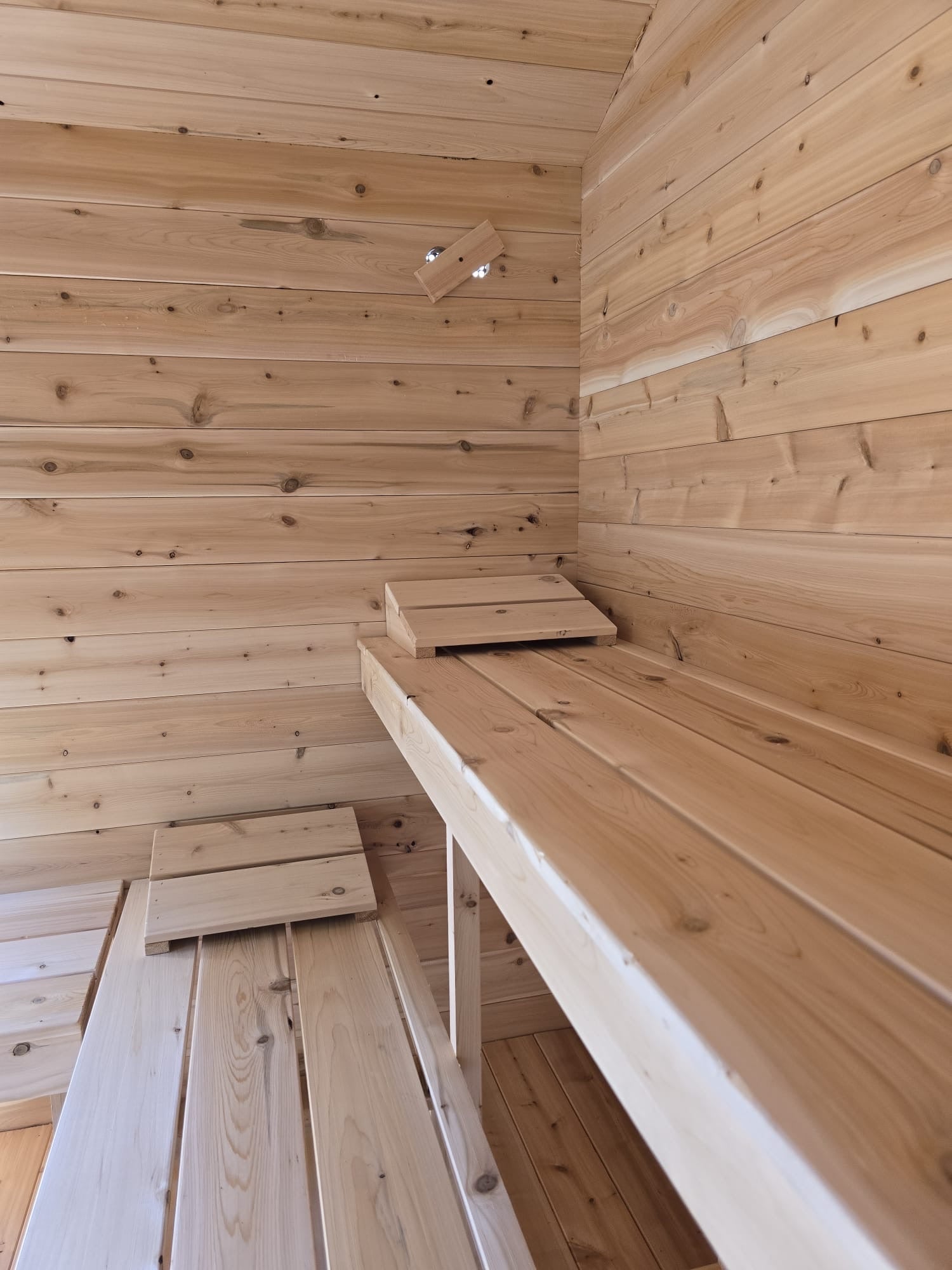 Wooden sauna interior with benches and ceiling