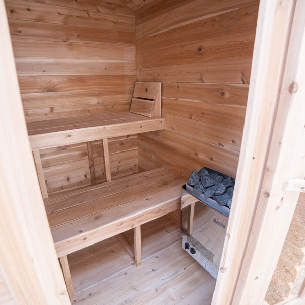 Wooden sauna interior with benches and electric heater.