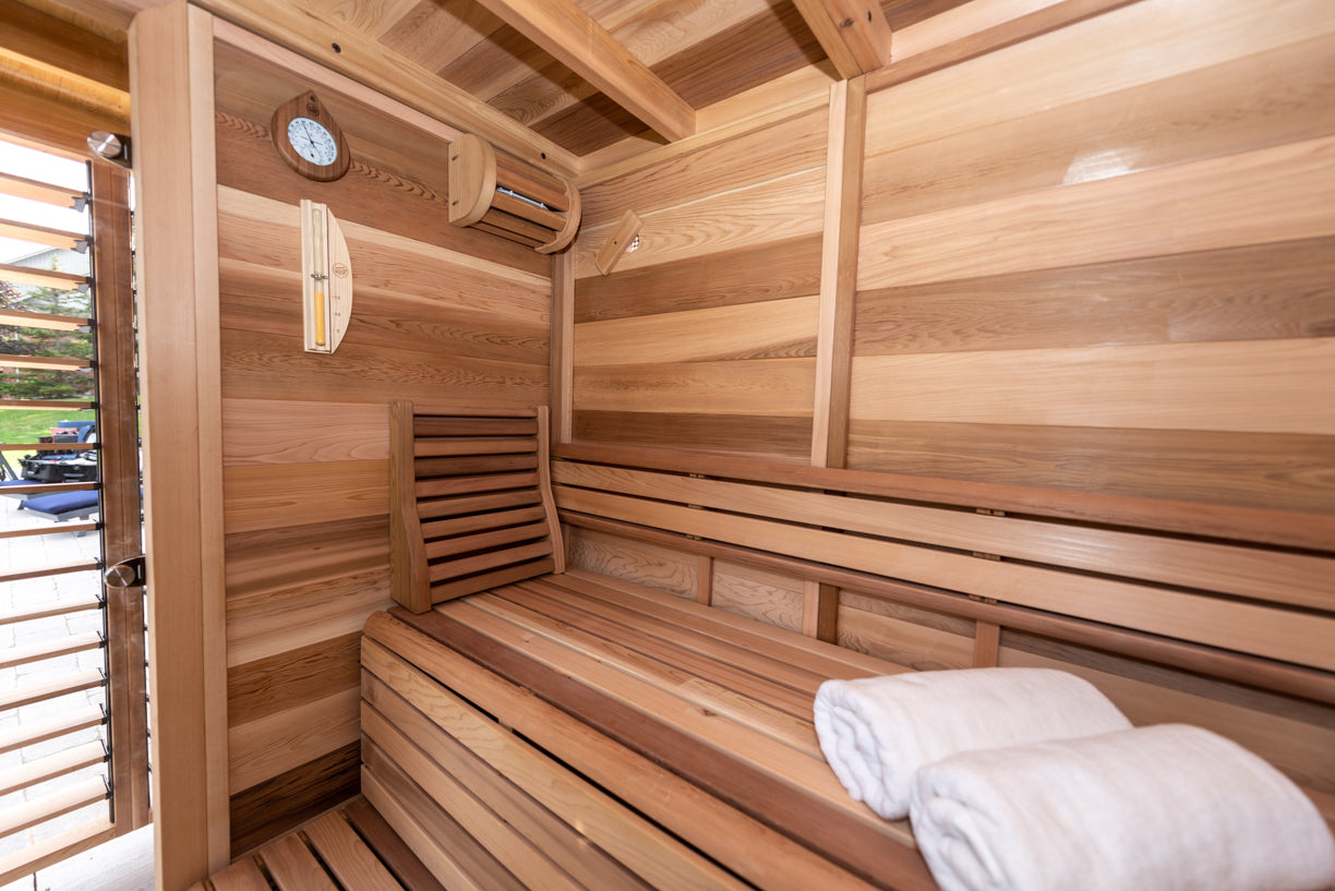 Wooden sauna with a bench and folded towels inside