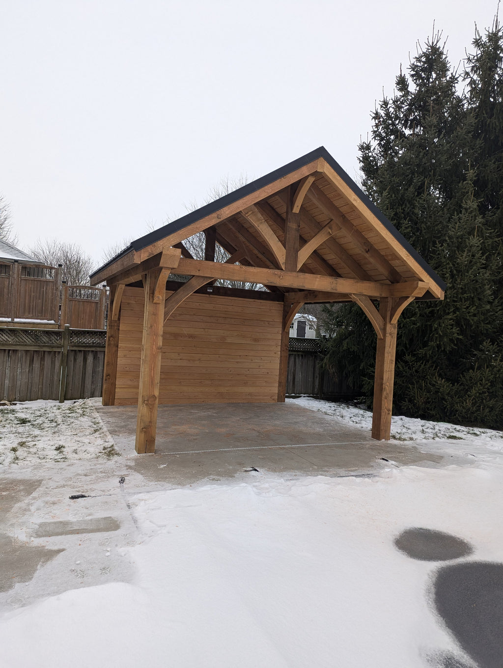 Wooden carport with snow on the ground