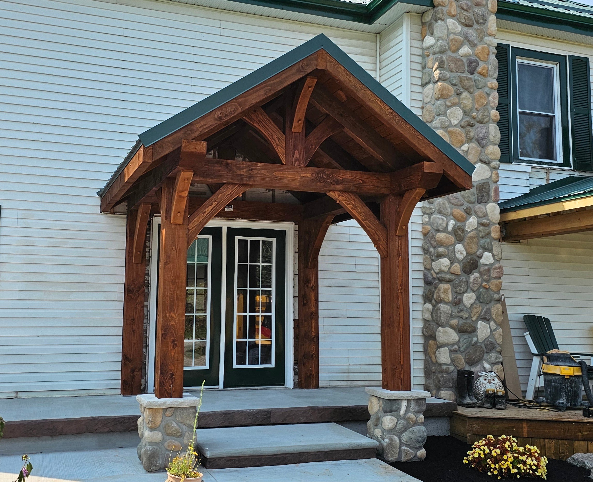Wooden porch with stone columns in front of a house