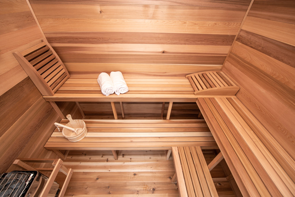 Wooden sauna interior with benches and towels