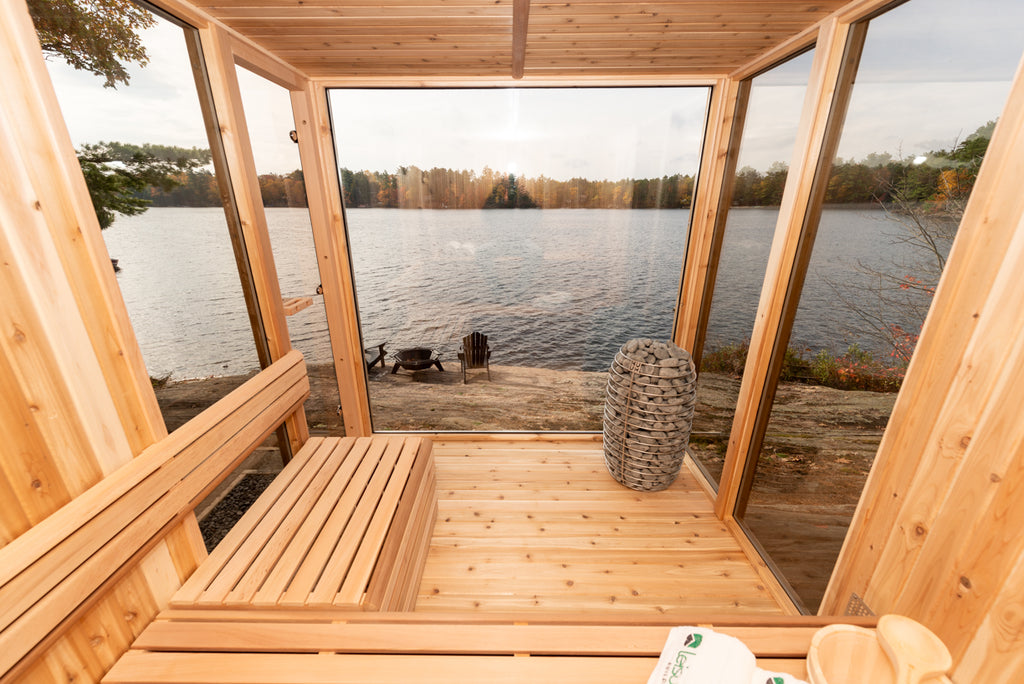 Wooden sauna with a view of a lake from inside.