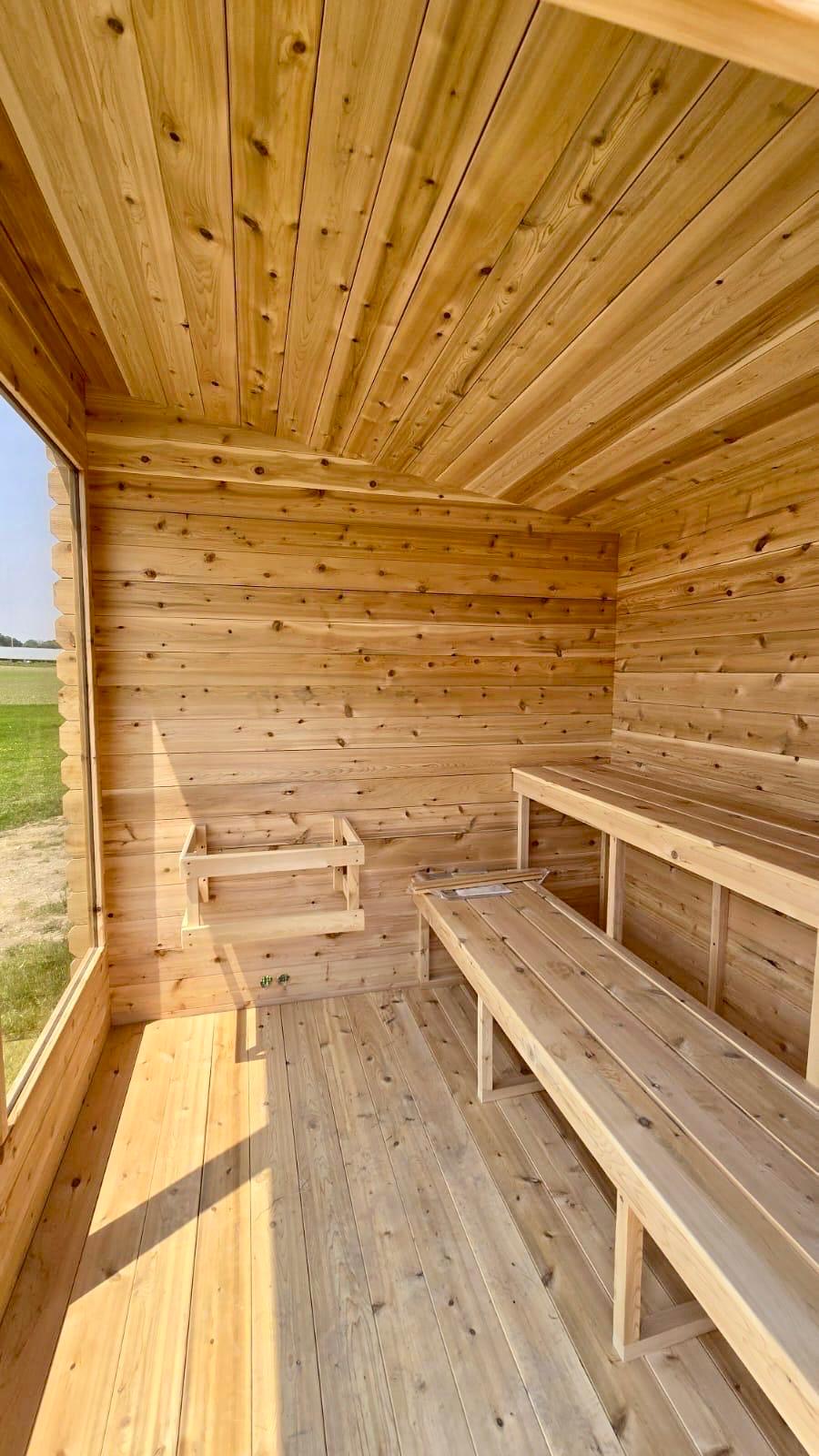 Wooden interior of a sauna with benches and a clear sky outside